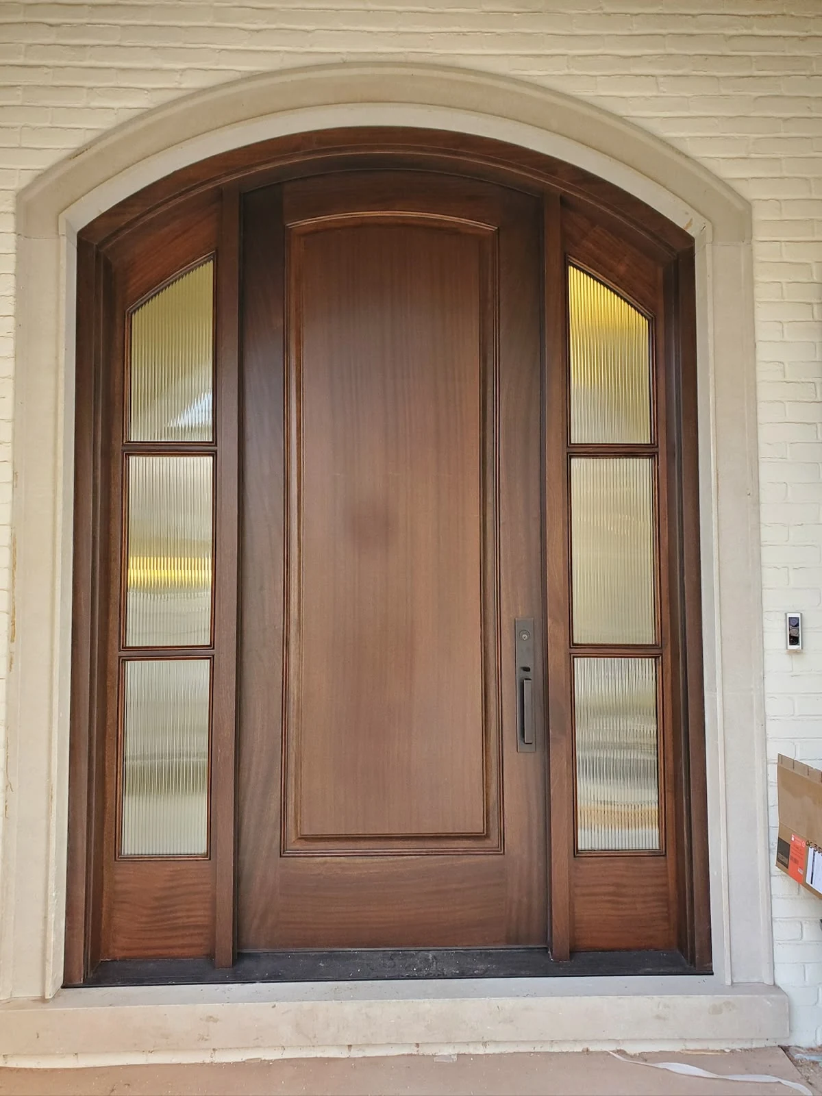 Finished arched wood entry with textured glass sidelights